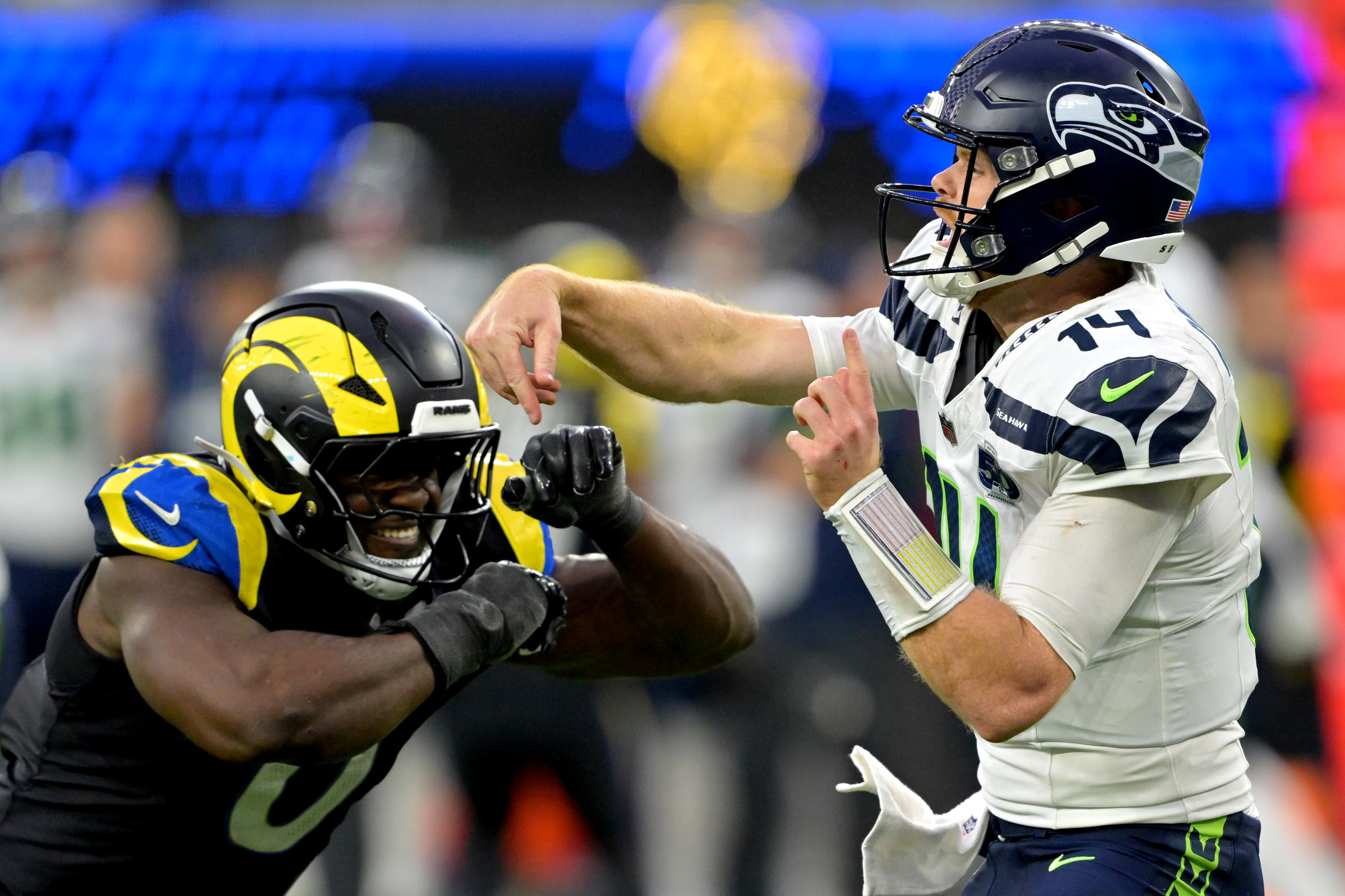 Seattle Seahawks quarterback Sam Darnold (14) is pressured by Los Angeles Rams defender Byron Young (0) as we break down the NFL weather report for Week 16