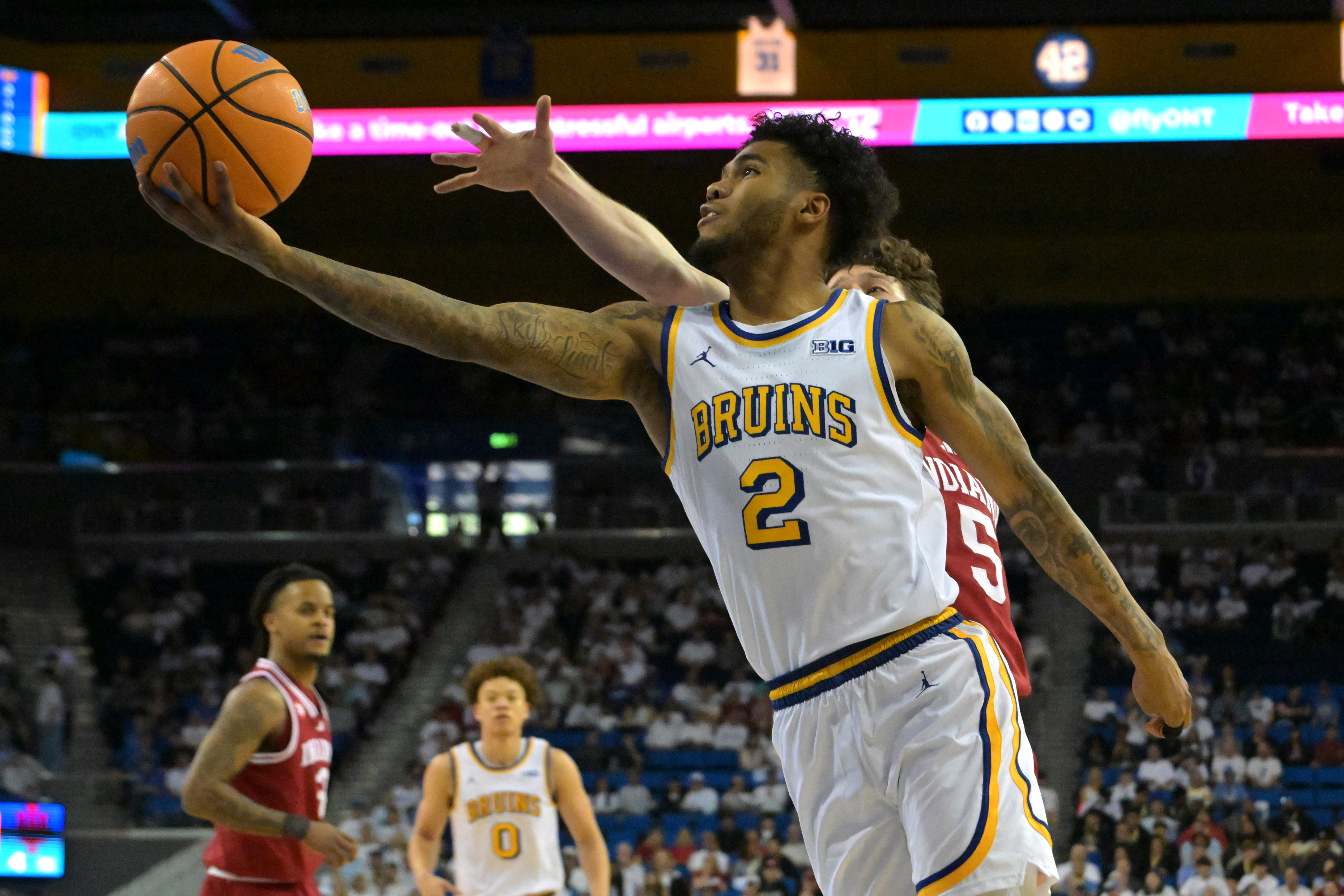UCLA Bruins guard Donovan Dent (2) is defended as we break down our UCLA vs. Michigan prediction, picks & odds.