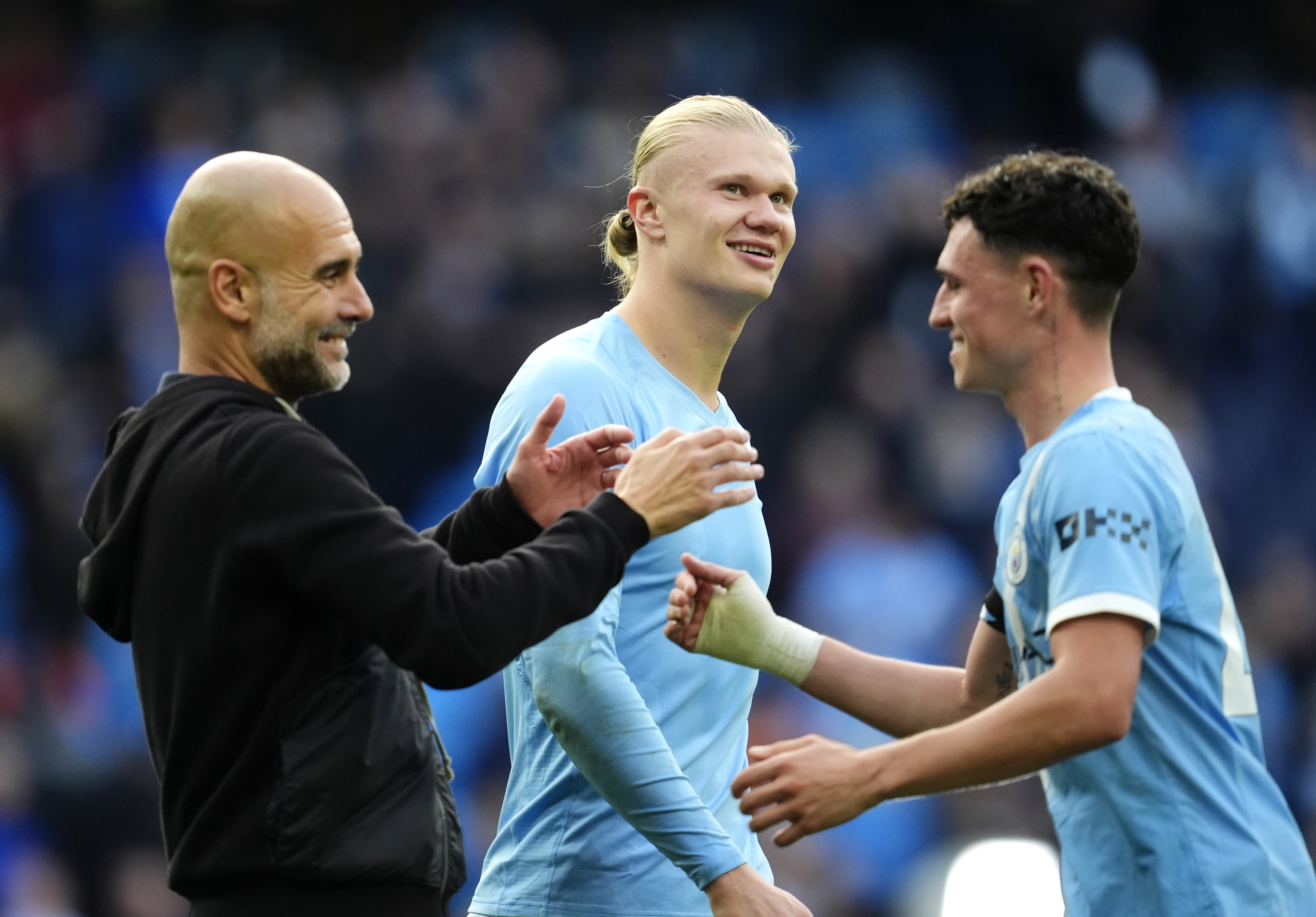 Manchester City manager Pep Guardiola, Erling Haaland, and Phil Foden celebrate as we make our best Man City vs. Leverkusen prediction.