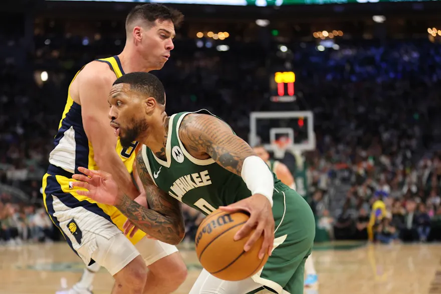 Milwaukee Bucks guard Damian Lillard (0) drives around Indiana Pacers wing Doug McDermott (20) as we offer our best Pacers vs. Bucks player props for Game 2 on Tuesday.