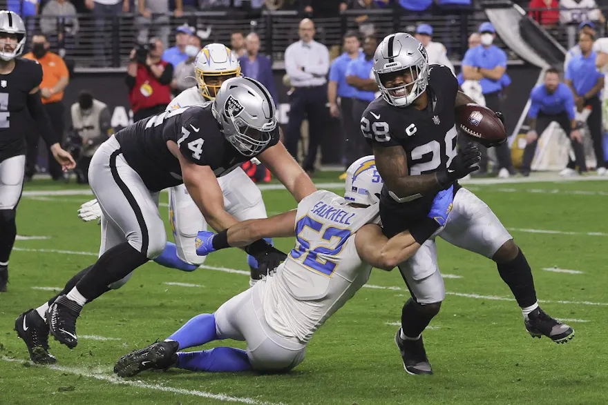 Kyler Fackrell of the Los Angeles Chargers tackles Josh Jacobs of the Las Vegas Raiders. 