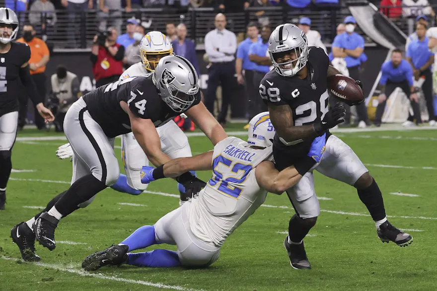 Kyler Fackrell of the Los Angeles Chargers tackles Josh Jacobs of the Las Vegas Raiders.