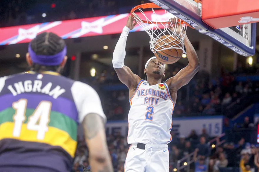 Shai Gilgeous-Alexander of the Oklahoma City Thunder dunks the ball while Brandon Ingram of the New Orleans Pelicans watches during the third quarter at Paycom Center on February 13, 2023. Is Oklahoma making progress on legal betting?
