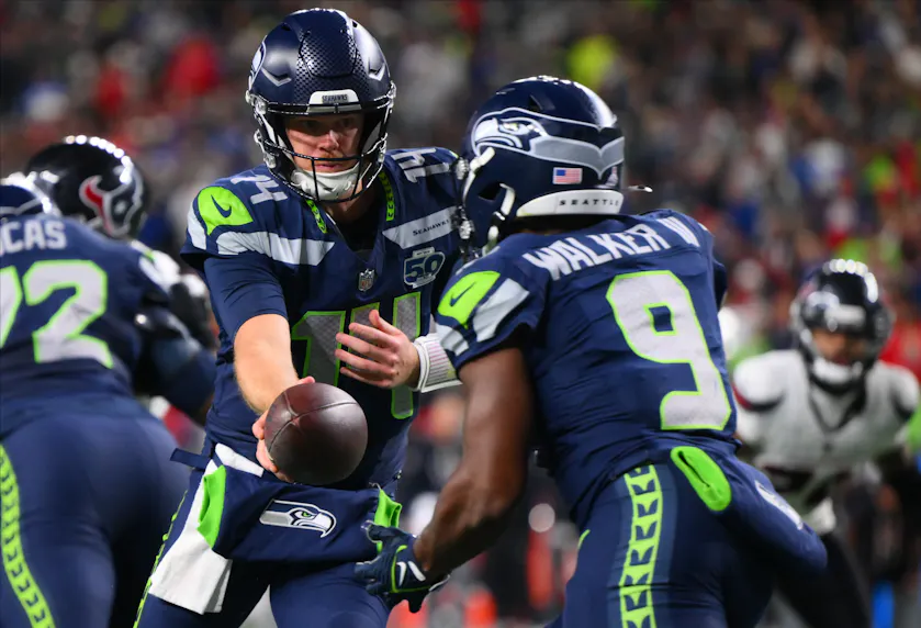 Seattle Seahawks quarterback Sam Darnold (14) hands the ball off to Seattle Seahawks running back Kenneth Walker III (9) as we look at the Sunday Night Football odds for Week 9