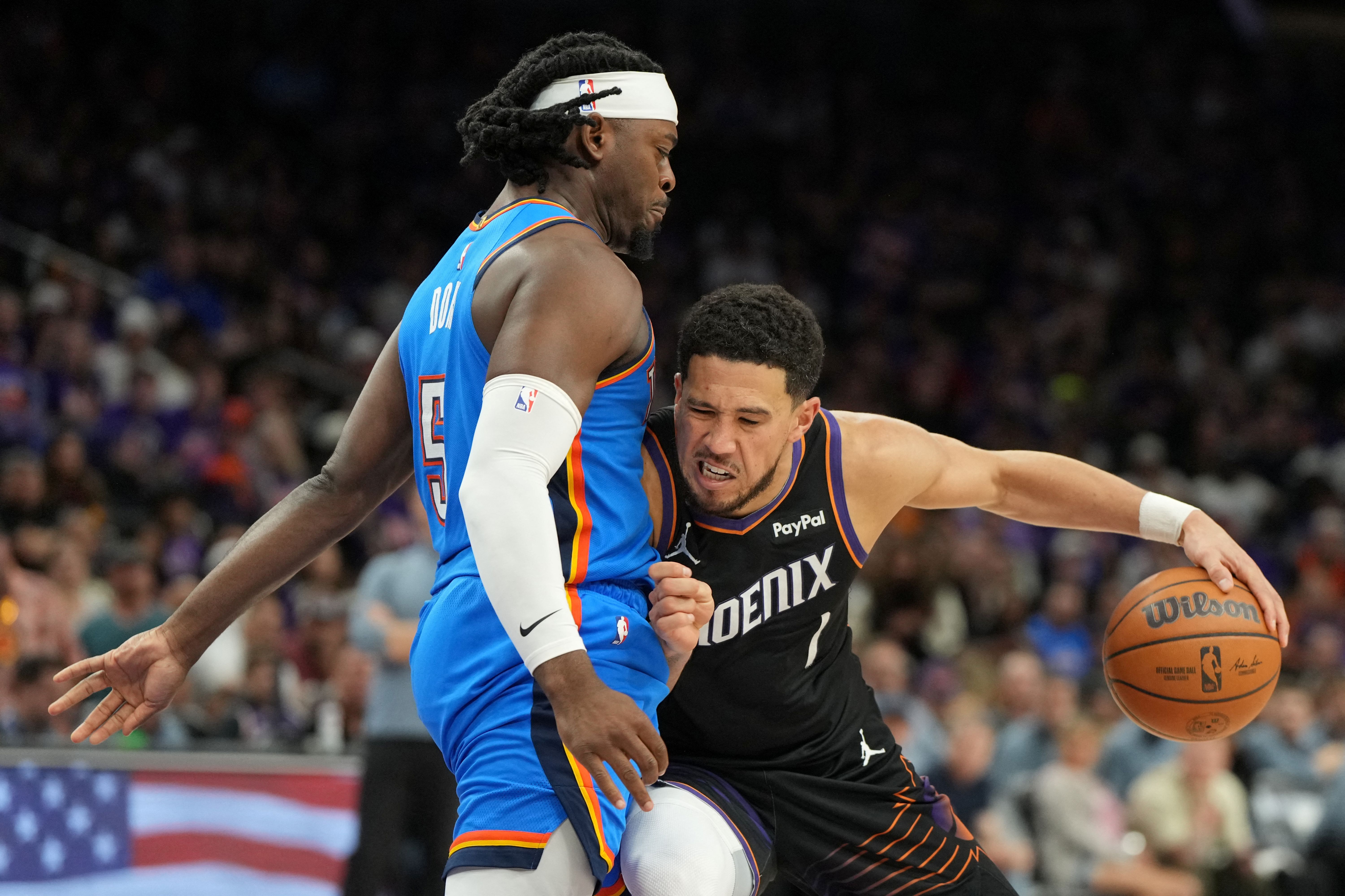 Phoenix Suns guard Devin Booker drives on Oklahoma City Thunder guard Luguentz Dort as we make our best Thunder vs. Suns player props