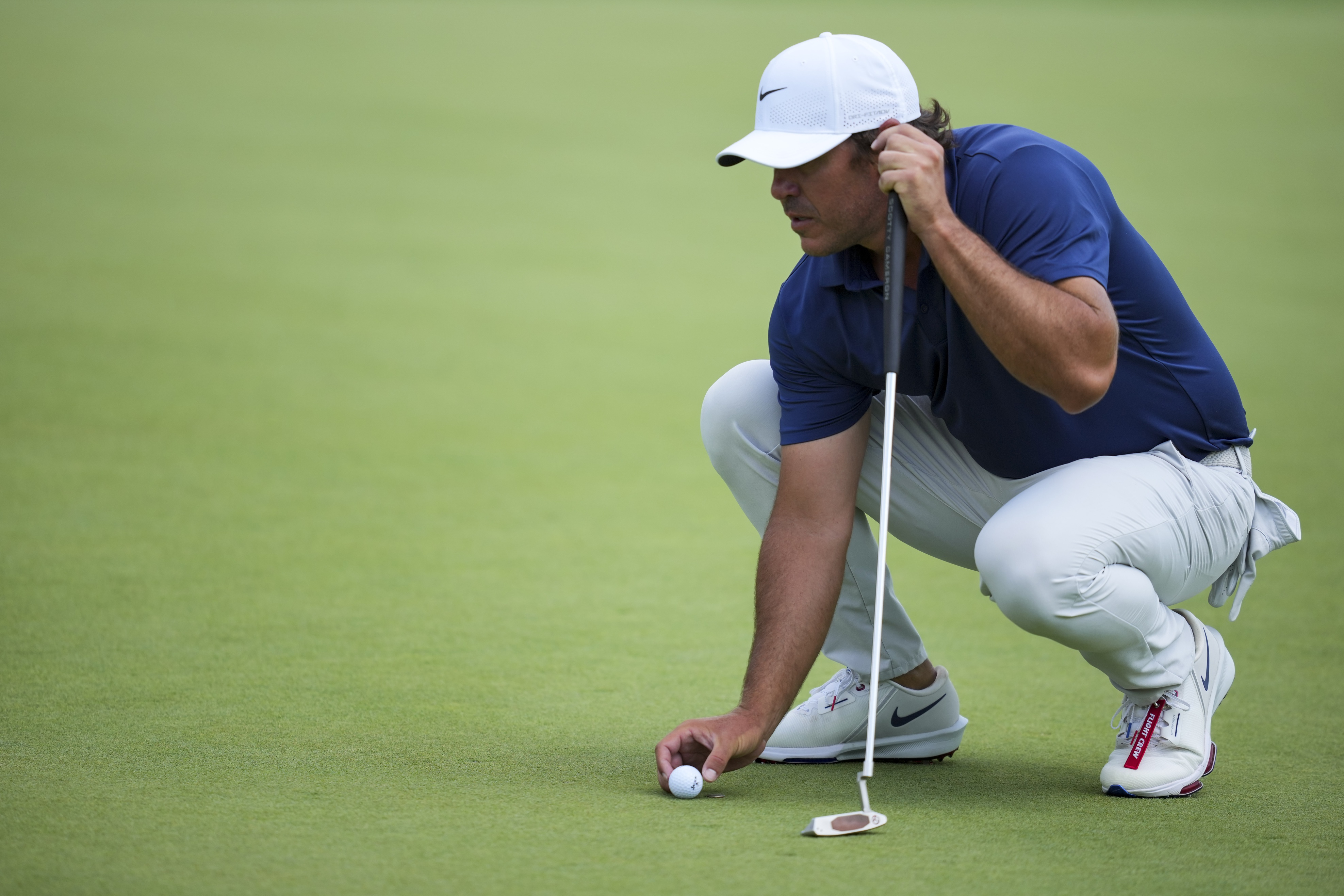 Brooks Koepka lines up a putt.