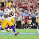 Jayden Daniels of the LSU Tigers scrambles against the Florida State Seminoles as we share our favorite LSU vs. Ole Miss prediction.