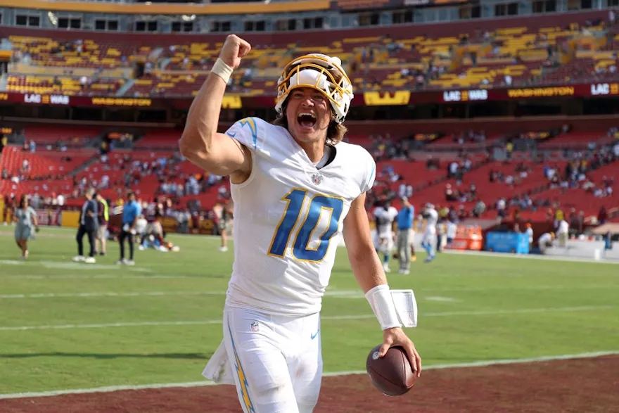 Quarterback Justin Herbert of the Los Angeles Chargers celebrates while leaving the field following his team's win over the Washington Commanders, and we offer our top player props for Patriots vs. Chargers based on the best NFL odds.