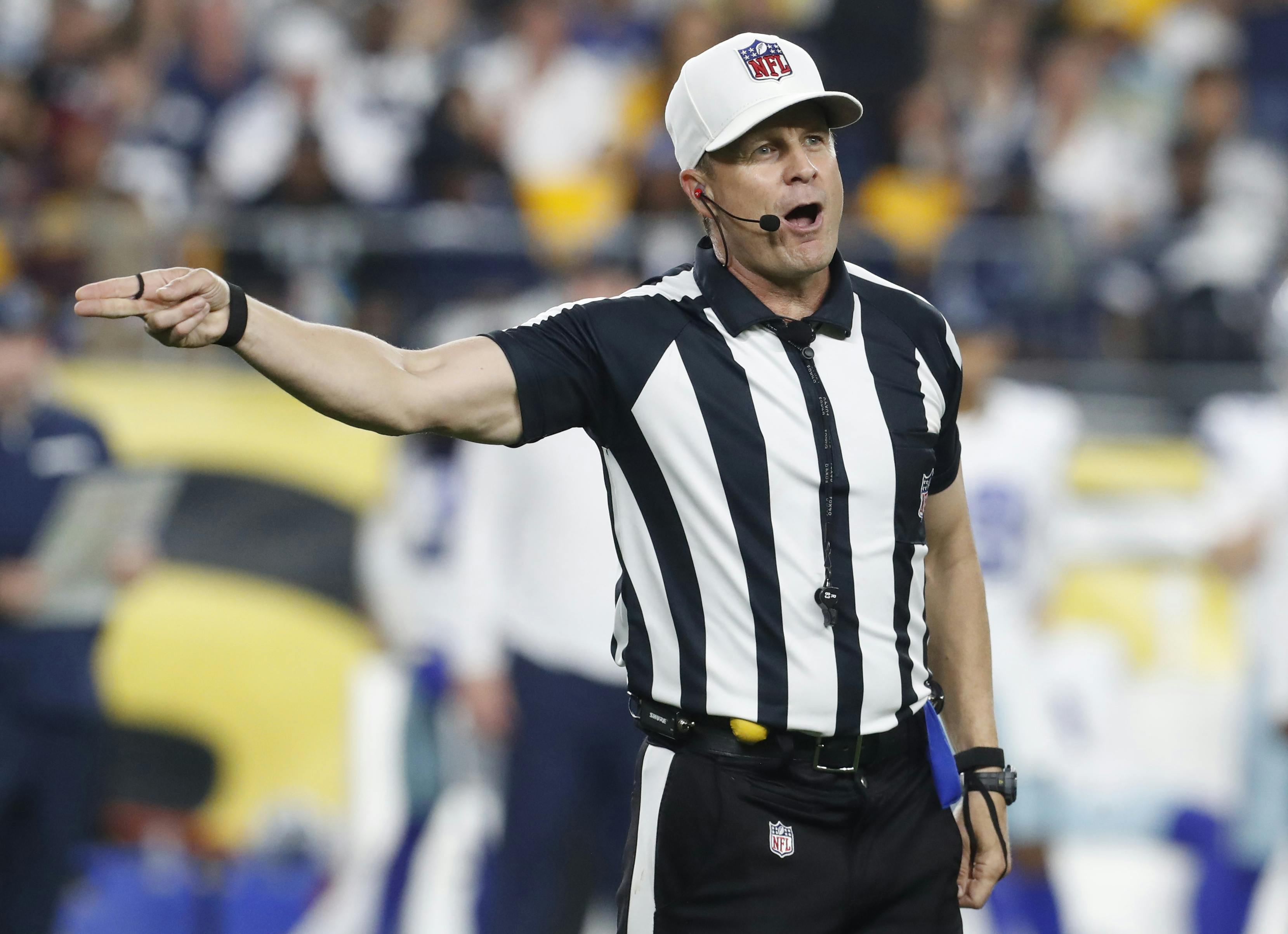 NFL referee Shawn Hochuli signals a penalty as we break down the NFL Conference Championship referee trends ahead of Championship Sunday.