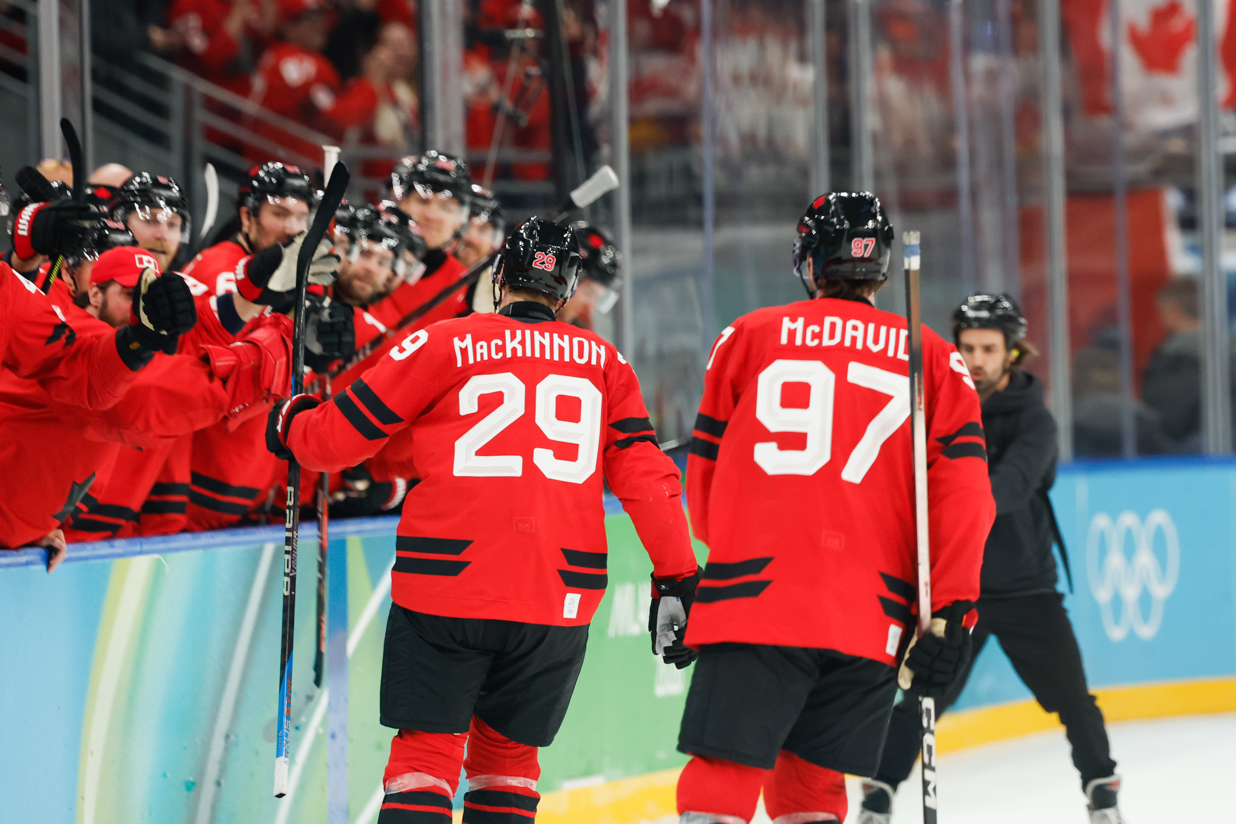 Nathan MacKinnon and Connor McDavid celebrating a goal as we offer our Canada vs. USA prediction, odds, and best bets for Sunday's gold medal game.