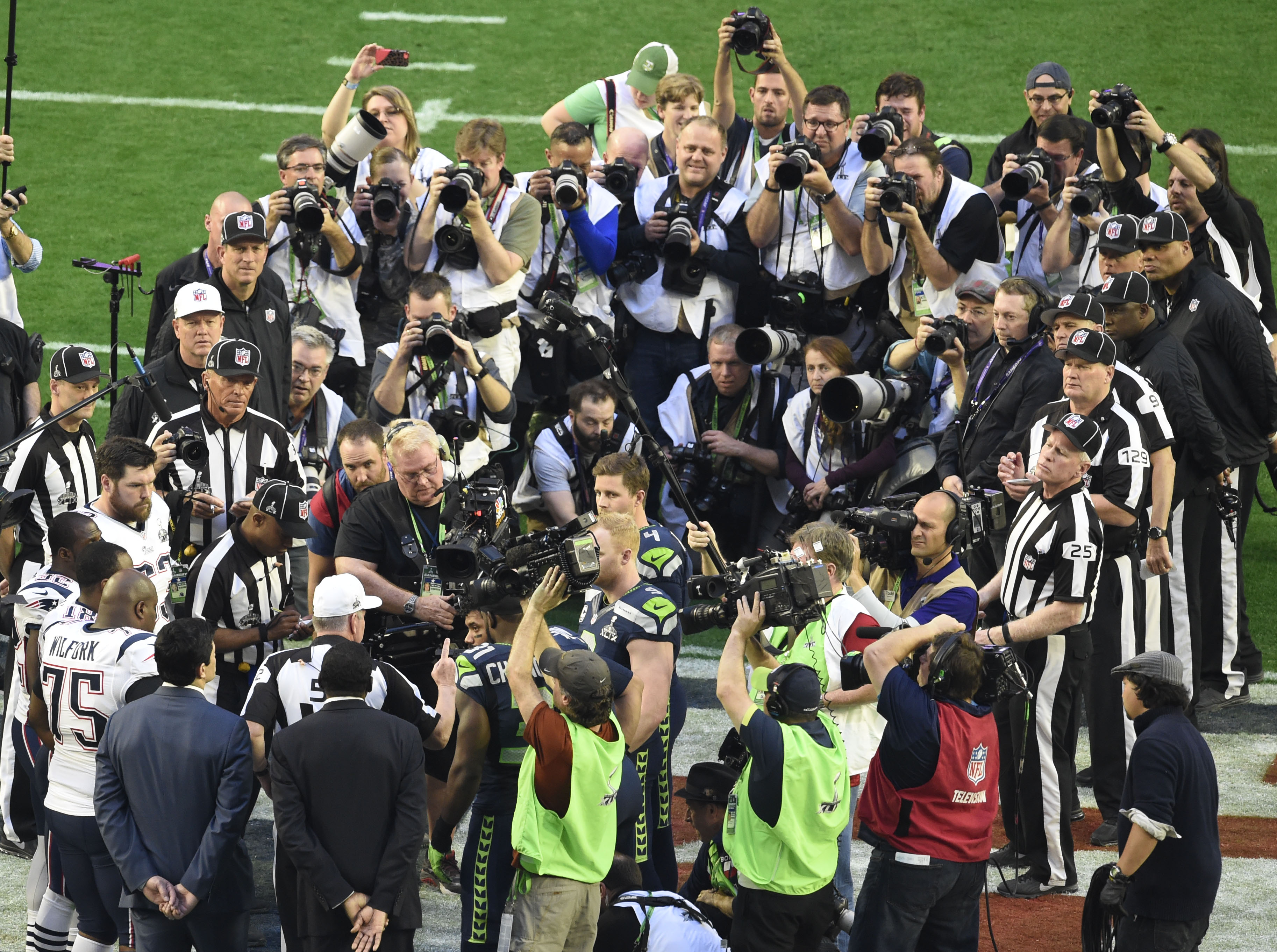 Photographers look on as the coin toss takes place before the Super Bowl, as we offer our Super Bowl coin toss predictions.