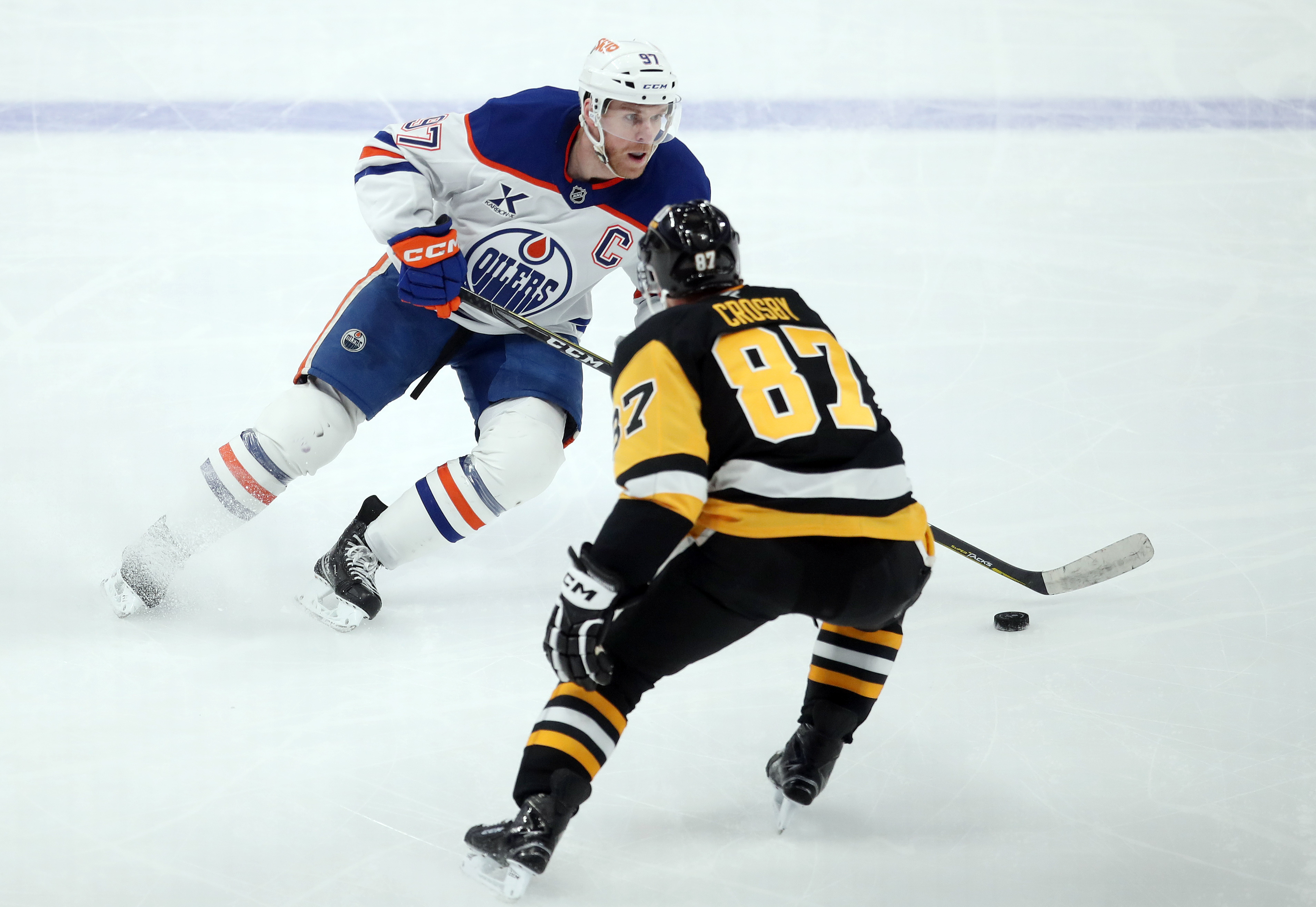 Penguins center Sidney Crosby (87) defends Oilers center Connor McDavid (97) as we offer our best Oilers vs. Penguins player props.