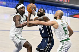 Dallas Mavericks guard Kyrie Irving drives to the basket between Boston Celtics guard Jrue Holiday and guard Derrick White during Game 4 of the 2024 NBA Finals. We're backing White in our Mavericks vs. Celtics Parlay. 
