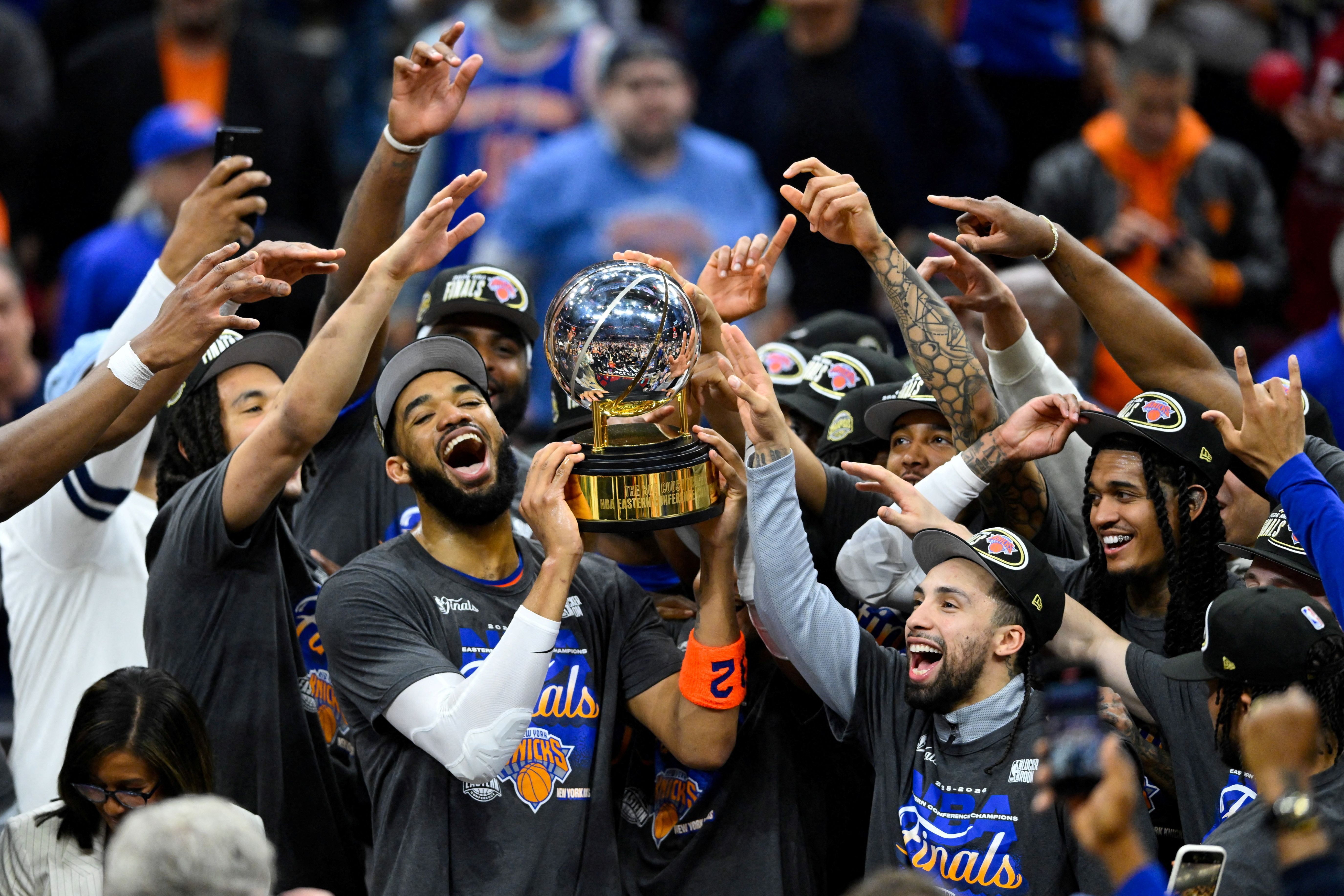 New York Knicks center Karl-Anthony Towns (32) lifts the 2026 Eastern Conference trophy with teammates after defeating the Cleveland Cavaliers in the Eastern Conference Finals.