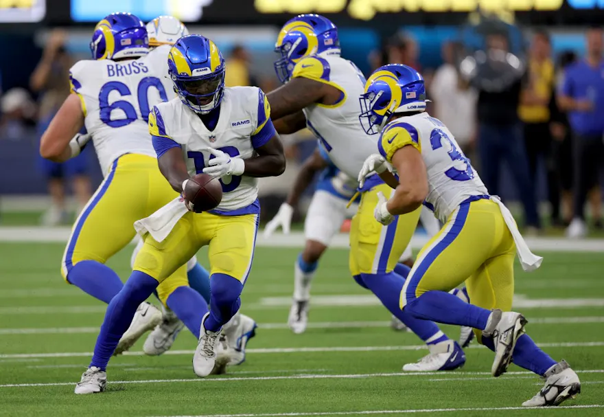 Bryce Perkins of the Los Angeles Rams hands the ball off to running back Jake Funk during a preseason game against the Los Angeles Chargers. Photo by Harry How/Getty Images via AFP.