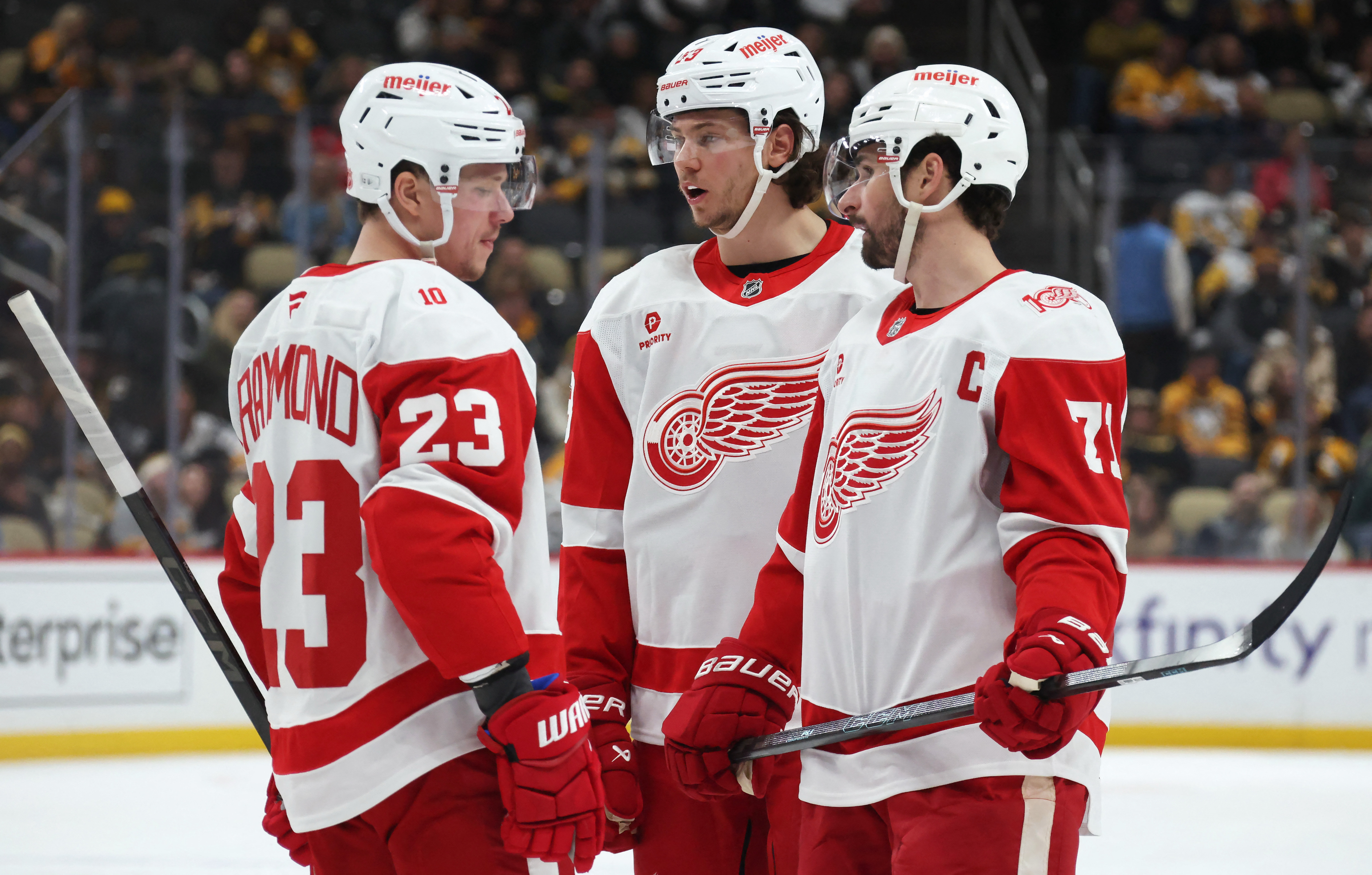 Detroit Red Wings players talk before a face-off as we offer our Red Wings vs. Bruins prediction.