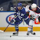 Connor McDavid of the Edmonton Oilers battles for the puck between Auston Matthews and Mitchell Marner of the Toronto Maple Leafs.