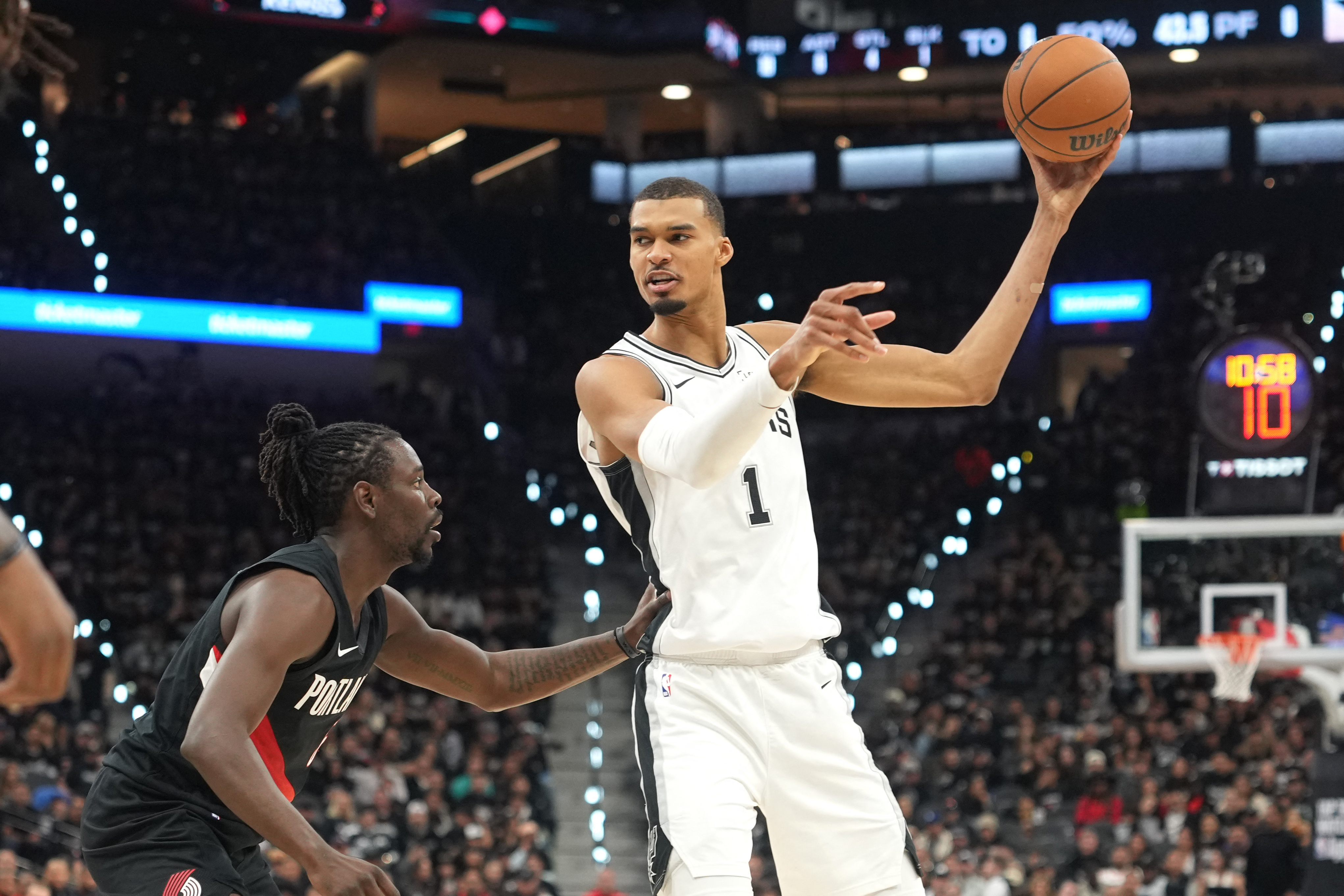 San Antonio Spurs forward Victor Wembanyama - who's featured in my Trail Blazers vs. Spurs player props - looks to pass against Portland Trail Blazers guard Jrue Holiday. 
