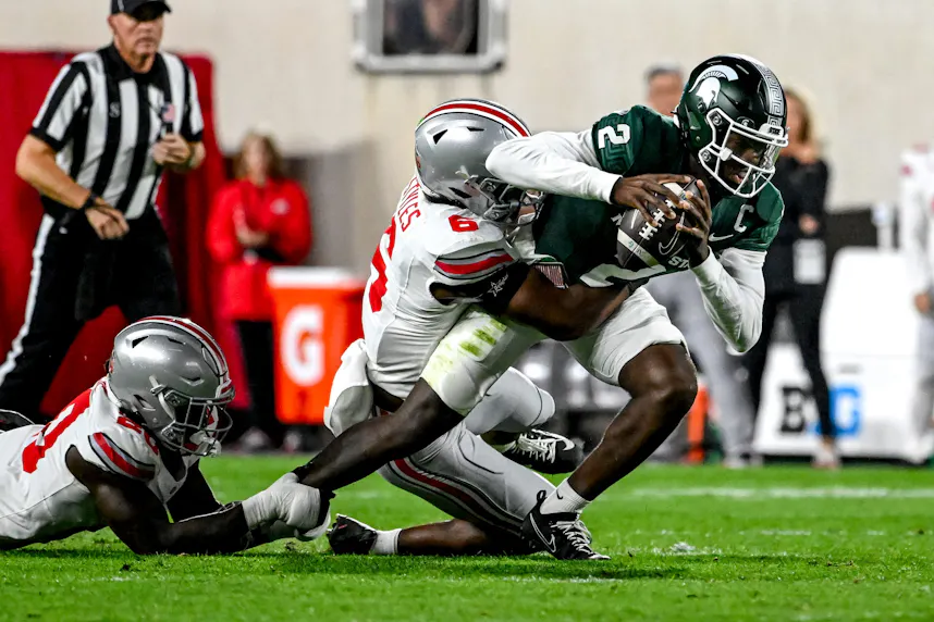 Michigan State's Aidan Chiles is tackled by Ohio State's Sonny Styles. We're fading the Spartans in our Michigan State vs. Oregon prediction.