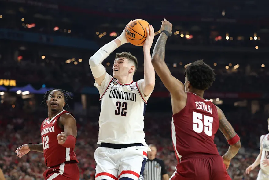 Donovan Clingan #32 of the Connecticut Huskies attempts a shot as we offer our best Purdue vs. UConn player props and predictions for the men's national championship game on Monday at State Farm Stadium in Glendale, Ariz.