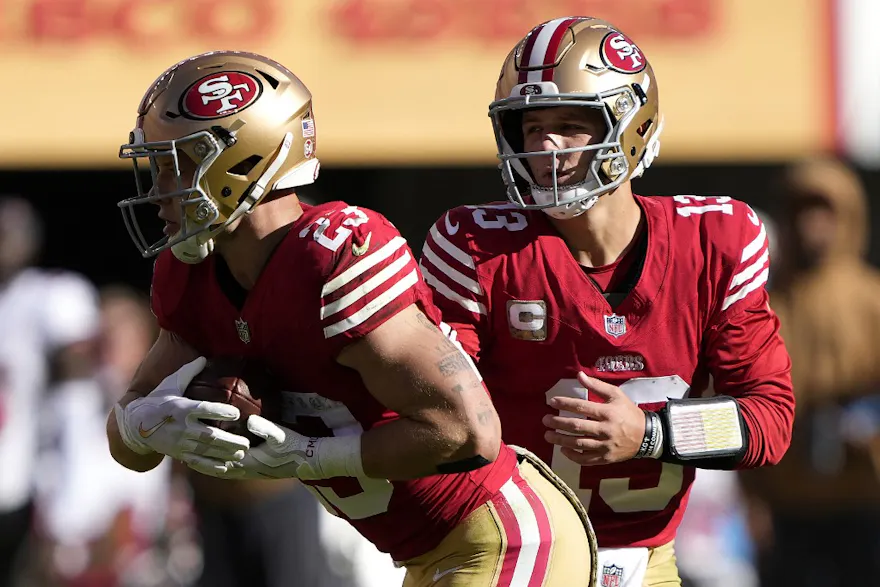 Brock Purdy #13 of the San Francisco 49ers hands off the ball as we round up our NFL Thanksgiving predictions.