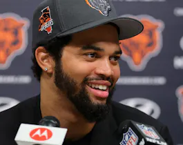 Chicago Bears QB Caleb Williams (18) answers a question during his introductory press conference, as we examine the 2024 NFL rookie passing leader odds with Williams as the betting favorite.