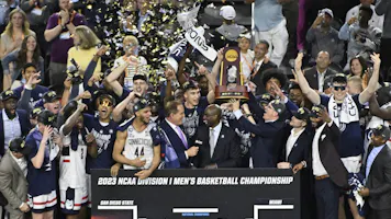 The Connecticut Huskies celebrate with the championship trophy as we look at the 2024 March Madness odds.
