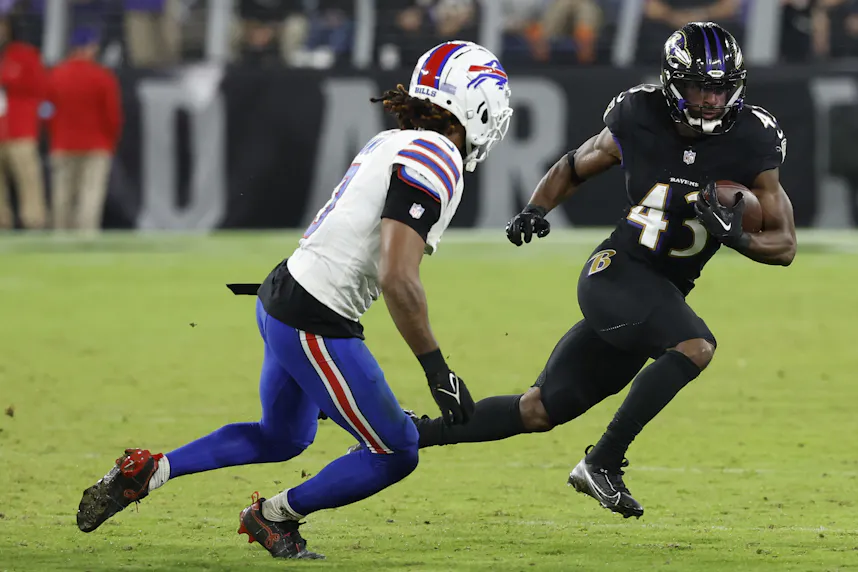 Baltimore Ravens running back Justice Hill carries the ball, as we offer our NFL Divisional Round predictions and odds for the second round of the NFL playoffs.