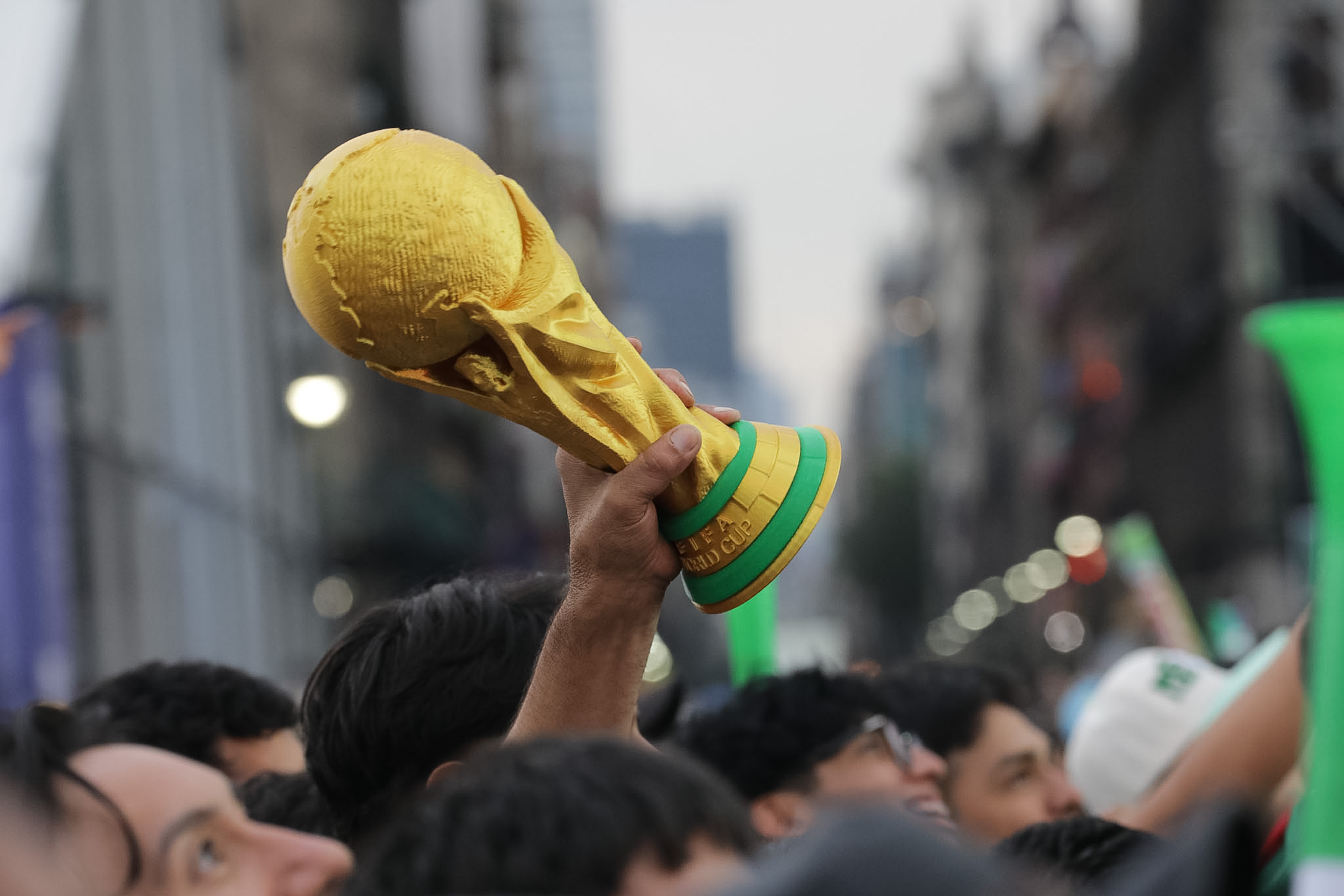 A person holds a replica of the FIFA World Cup trophy as we look at prediction markets overtaking sportsbooks during the World Cup