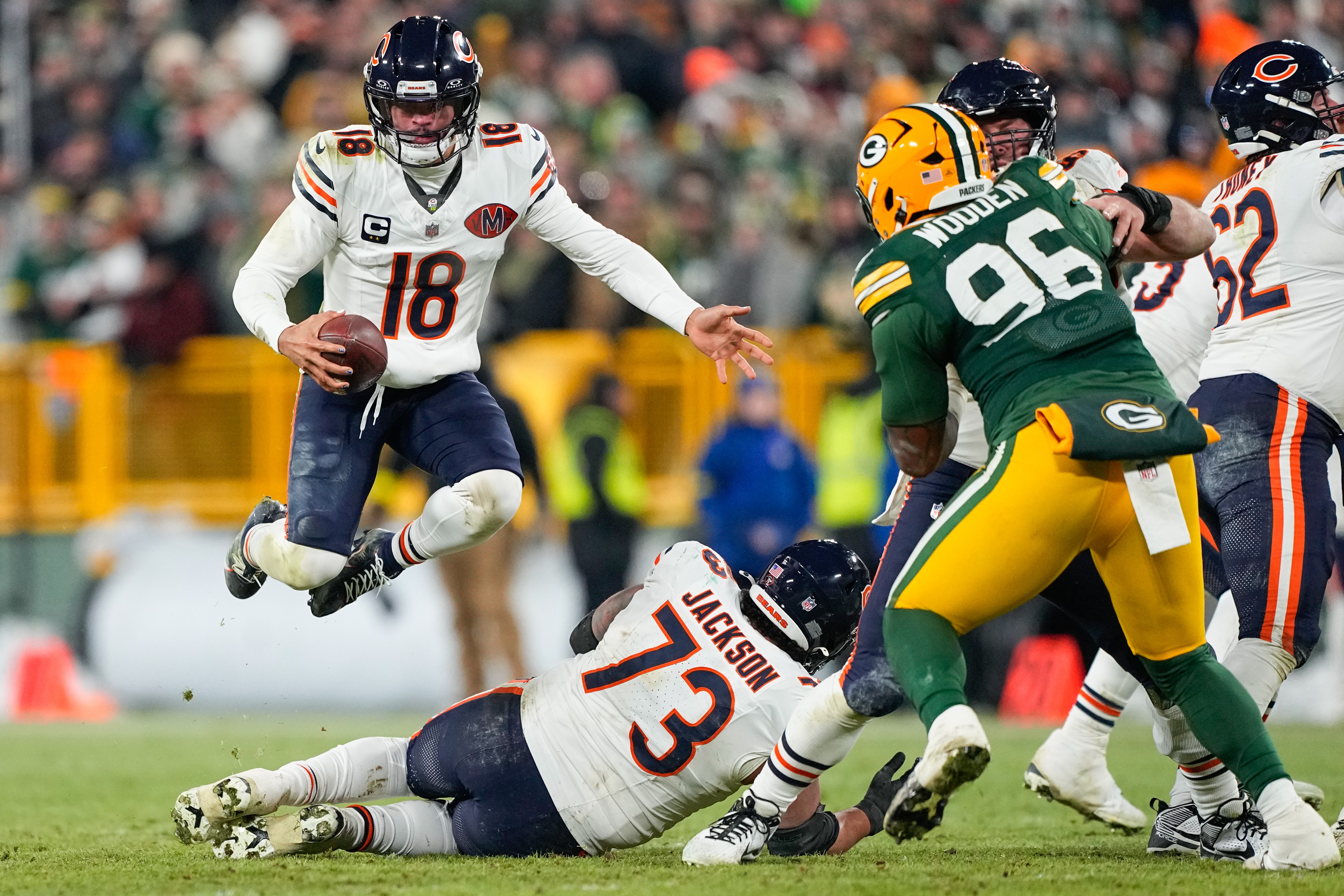 Chicago Bears quarterback Caleb Williams (18) hurdles over offensive lineman Jonah Jackson (73) as we break down the NFL weather report for the Wild Card Round.