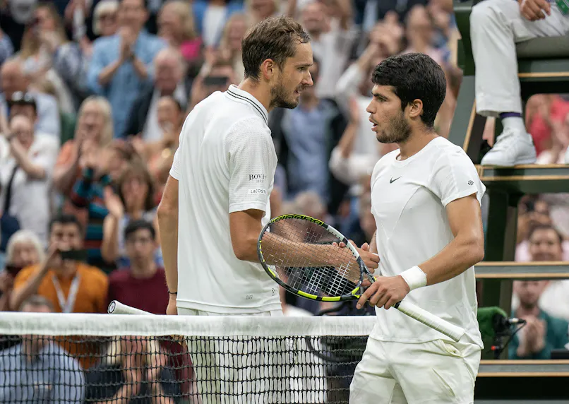 Carlos Alcaraz and Daniil Medvedev at the net as we offer our best Medvedev vs. Alcaraz predictions and odds for Friday's semifinal match at Wimbledon 2024.
