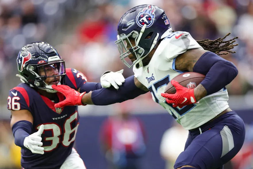Derrick Henry of the Tennessee Titans runs with the ball as Jonathan Owens of the Houston Texans.