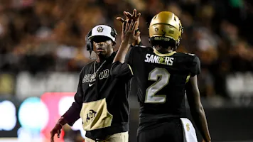 Head coach Deion Sanders of the Colorado Buffaloes celebrates with quarterback Shedeur Sanders after a fourth-quarter touchdown against the Colorado State Rams as we look at BetMGM's problem gambling initiative in Colorado.