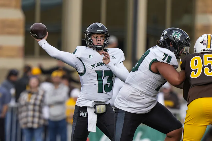 Hawaii Rainbow Warriors quarterback Brayden Schager throws as we make our best Delaware State vs. Hawaii prediction & picks.