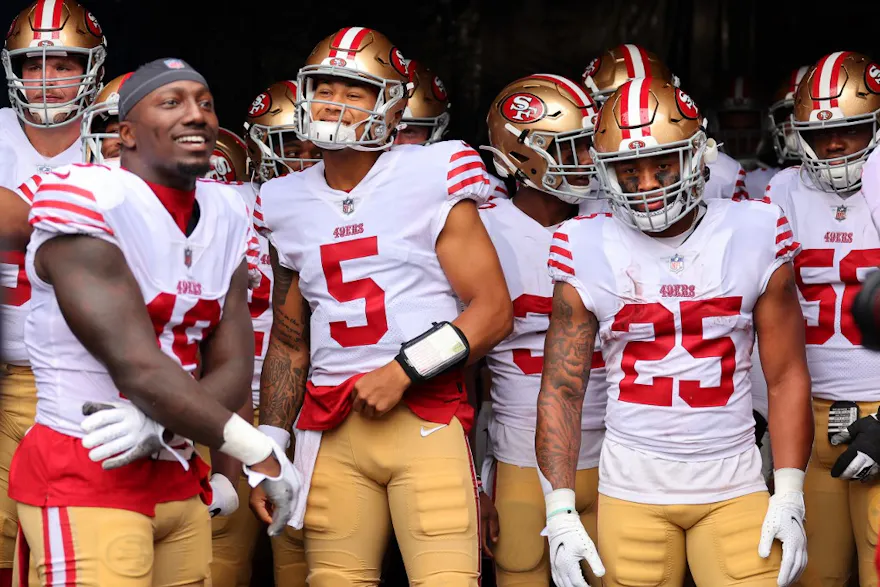 Deebo Samuel, Trey Lance, and Elijah Mitchell of the San Francisco 49ers look on before taking the field against the Chicago Bears.