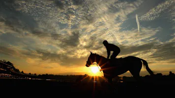 Horse and rider train as the sun rises at Saratoga Racetrack as we look at the deal between DraftKings and the NYRA.
