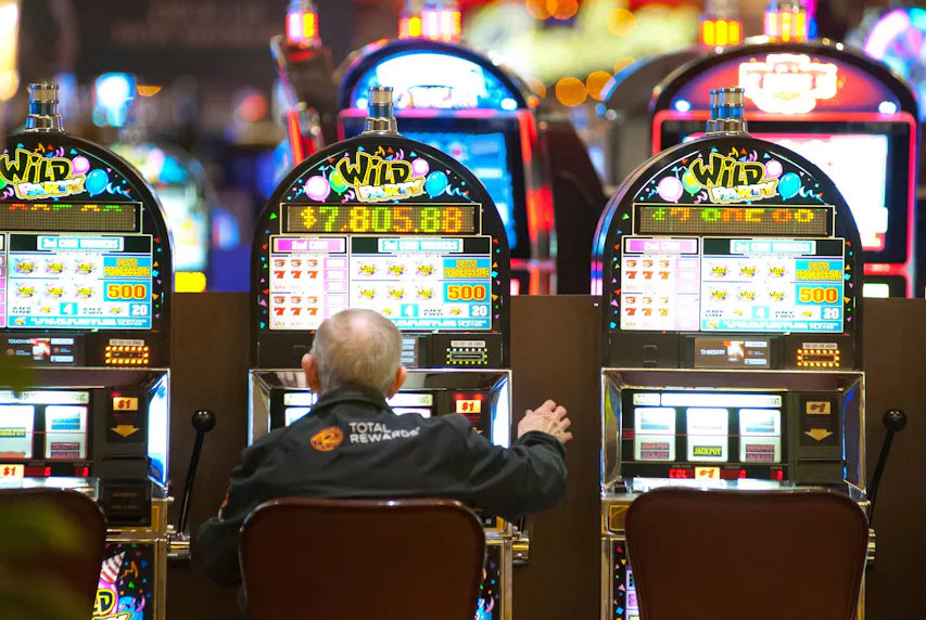 A slot machine patron pulls the lever as we look at Horseshoe Casino launching in Michigan
