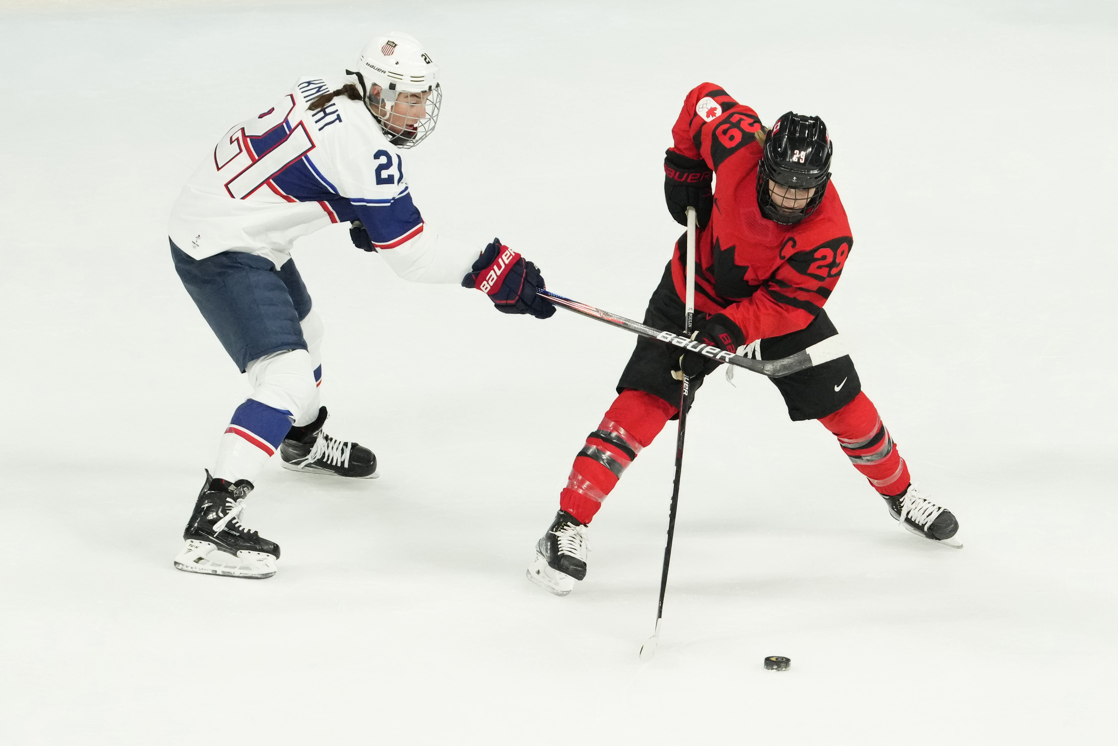 Team Canada forward Marie-Philip Poulin (29) skates with the puck as Team United States forward Hilary Knight (21) defends as we offer our USA vs. Canada anytime goal scorer predictions.