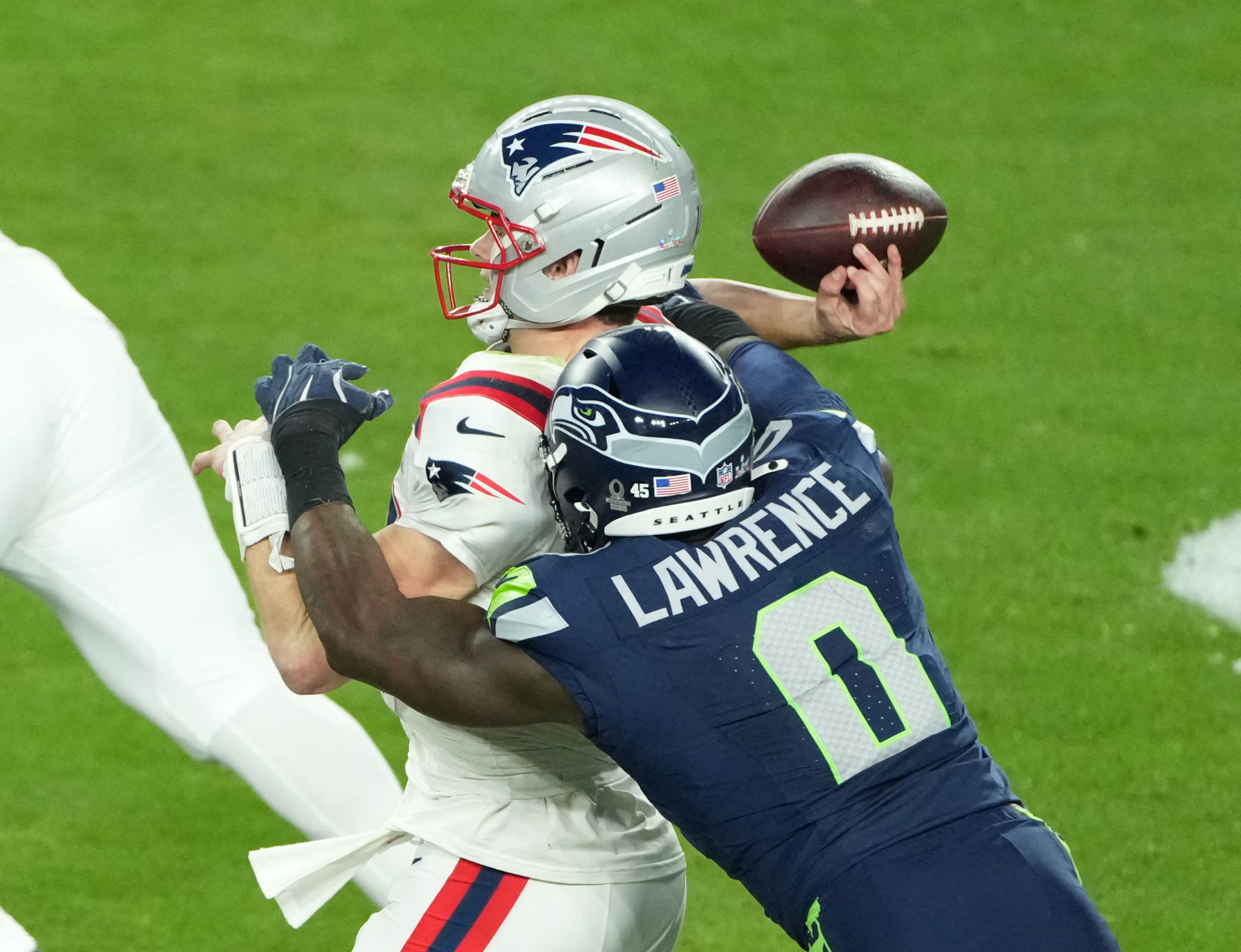 New England Patriots quarterback Drake Maye is hit as he throws by Seattle Seahawks defensive end DeMarcus Lawrence as we look at the Super Bowl sacks prop odds