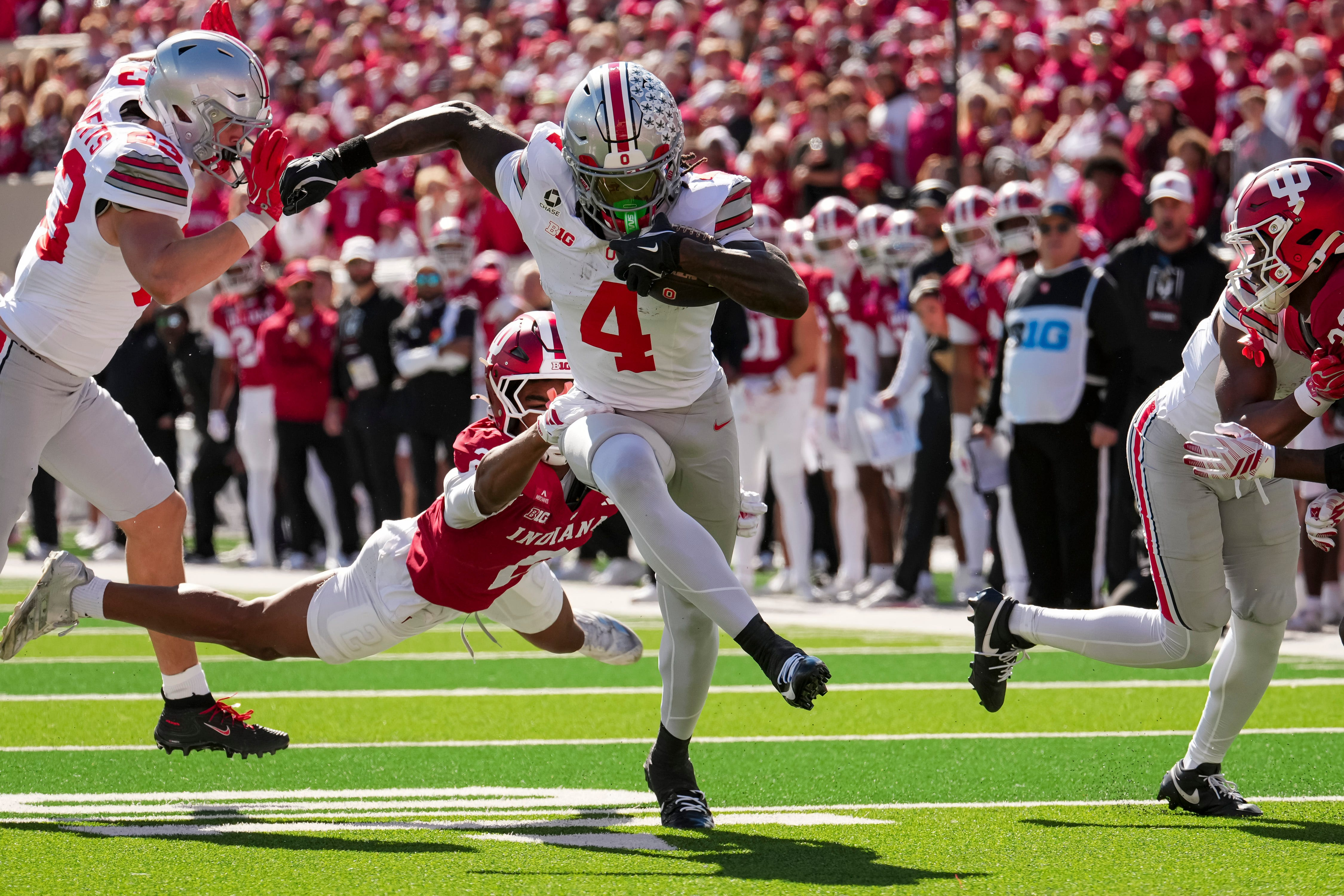 Ohio State Buckeyes wide receiver Jeremiah Smith (4) runs past Indiana Hoosiers defensive back Byron Baldwin Jr. (2) as we look at the latest Heisman odds. 