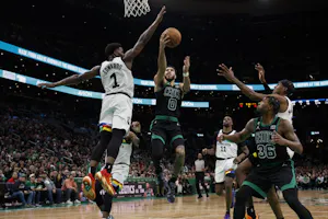 Jayson Tatum (0) of the Boston Celtics drives against Anthony Edwards (1) of the Minnesota Timberwolves, as we look at the latest 2024 NBA championship odds with the Celtics and Timberwolves favorites to win the NBA Finals.