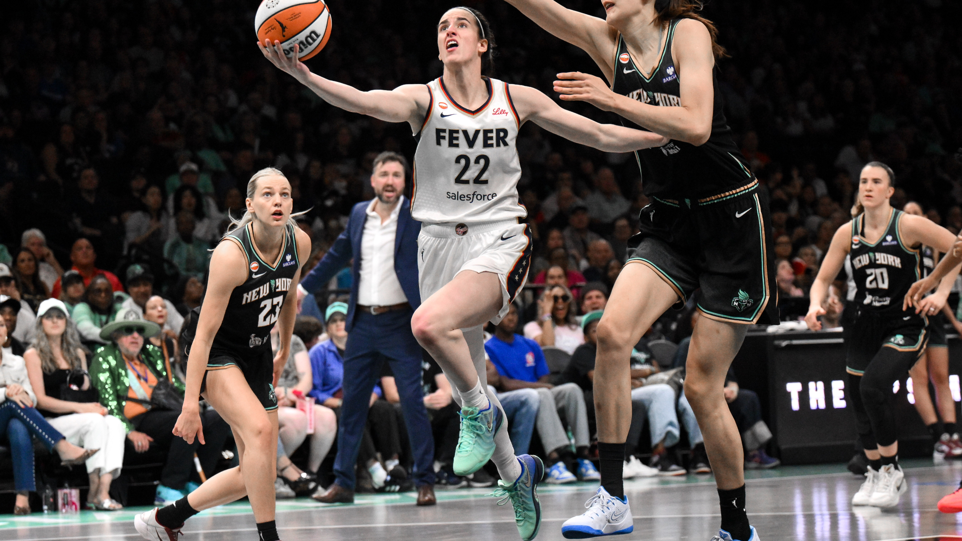 Indiana Fever guard Caitlin Clark (22) drives as she is featured in our Sun vs. Fever prediction.