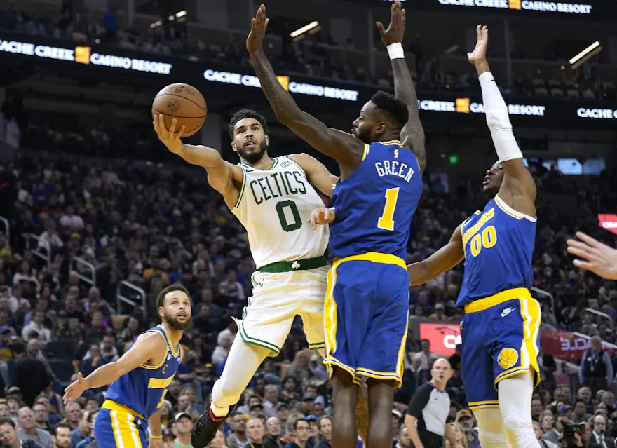 Jayson Tatum of the Boston Celtics shoots over JaMychal Green of the Golden State Warriors during the first quarter of an NBA basketball game at Chase Center on December 10, 2022 in San Francisco, California.
