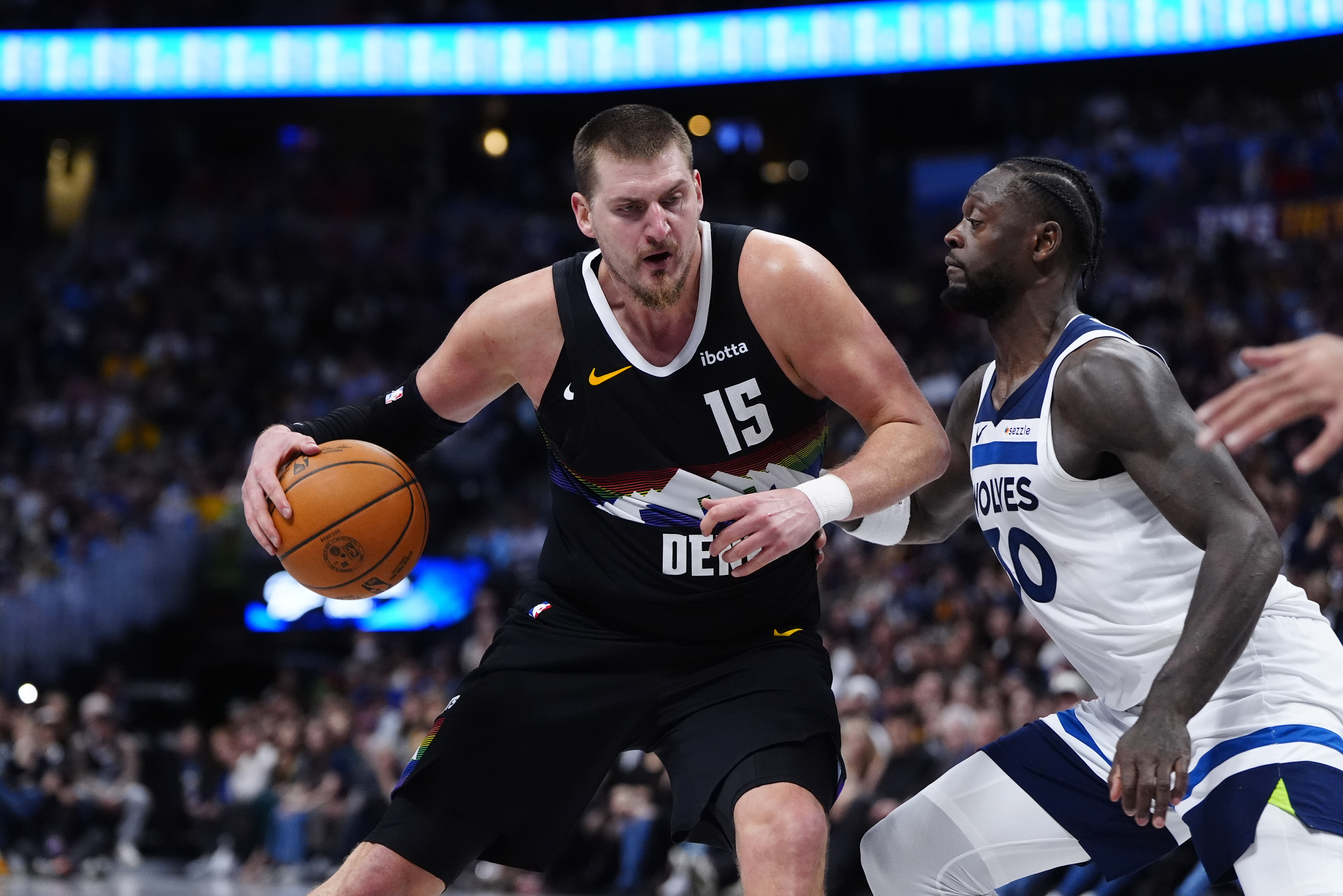 Minnesota Timberwolves forward Julius Randle (30) defends on Denver Nuggets center Nikola Jokic (15) at Ball Arena. Jokic is featured in our Timberwolves vs. Nuggets prediction for the 2026 NBA playoffs.