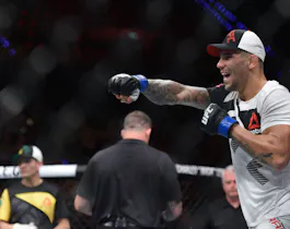 Aleksander Rakic (blue gloves) reacts to a fight as we make our best UFC 321 parlay picks.