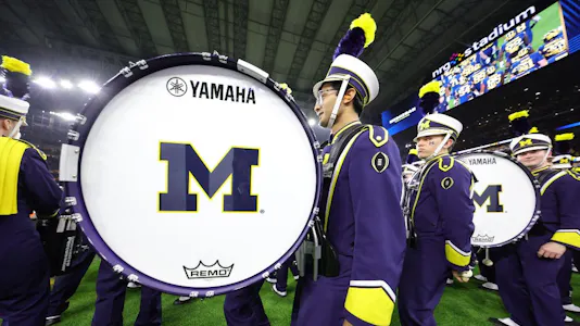 The Michigan Wolverines band on the field prior to the 2024 CFP National Championship game as we look at the best odds.