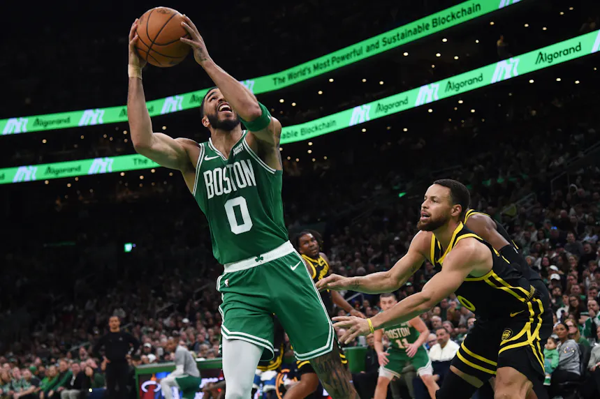 Boston Celtics forward Jayson Tatum controls the ball while Golden State Warriors guard Stephen Curry defends as we make our best Warriors vs. Celtics player props.