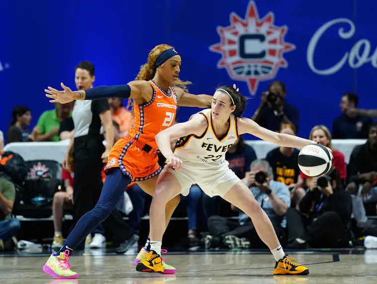 Indiana Fever guard Caitlin Clark (22) moves the ball against Connecticut Sun guard DiJonai Carrington (21) as we offer our best Sun vs. Fever prediction and expert picks for Wednesday's WNBA matchup at Gainbridge Fieldhouse in Indianapolis.