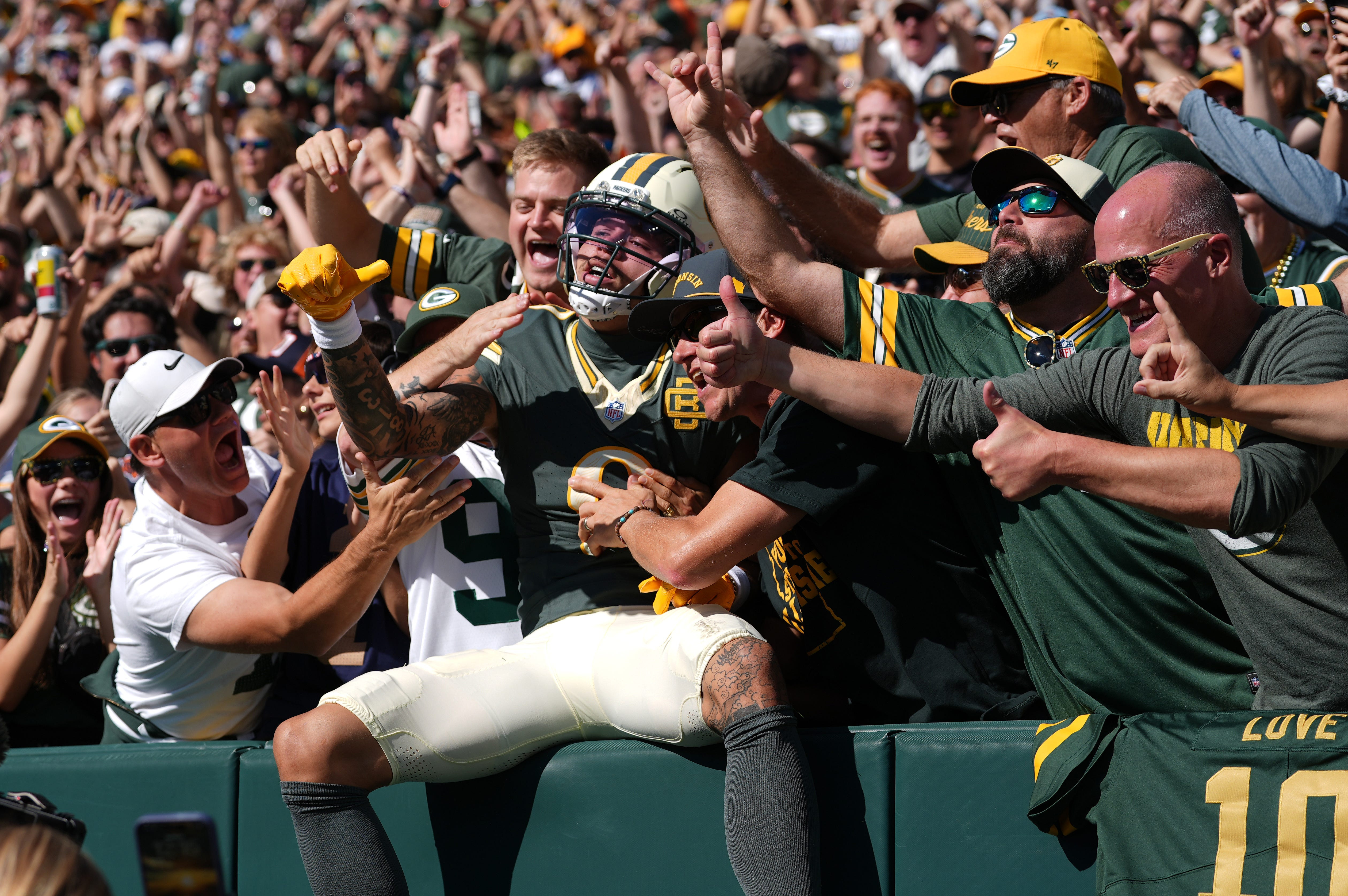 Green Bay Packers wide receiver Christian Watson (9) does a Lambeau Leap after scoring a touchdown as he is featured in our NFL anytime touchdown scorer predictions.