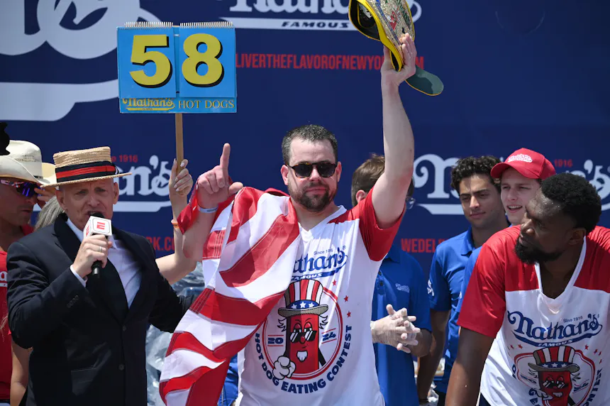 Patrick Bertoletti holds up the Mustard Belt after winning the 2024 Nathan's Famous International Hot Dog Eating Contest at Coney Island in Brooklyn, N.Y.